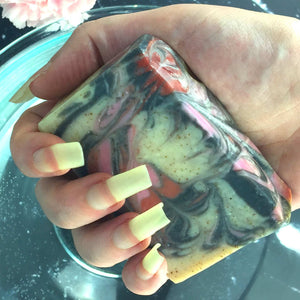 Cherry Almond Artisan Soap in hand with long natural fingernails